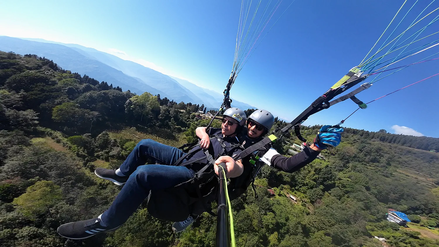 Tandem paragliding flight above the forests and hills of Sadam